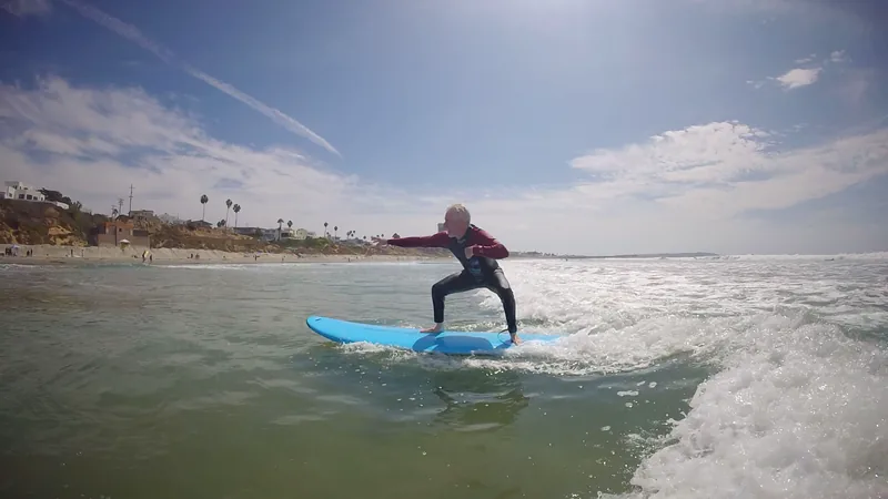 A surfer practicing riding a wave on a blue board